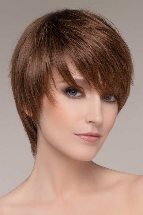 Woman in a medium brown long side swept pixie wig