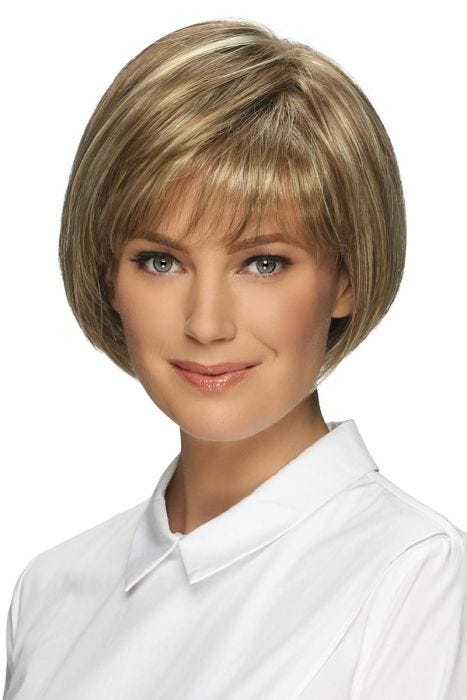 Woman in a chin length light brown rounded bob wig with textured bangs