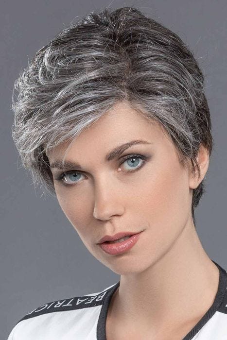 Woman in a tousled salt and pepper layered human hair pixie wig