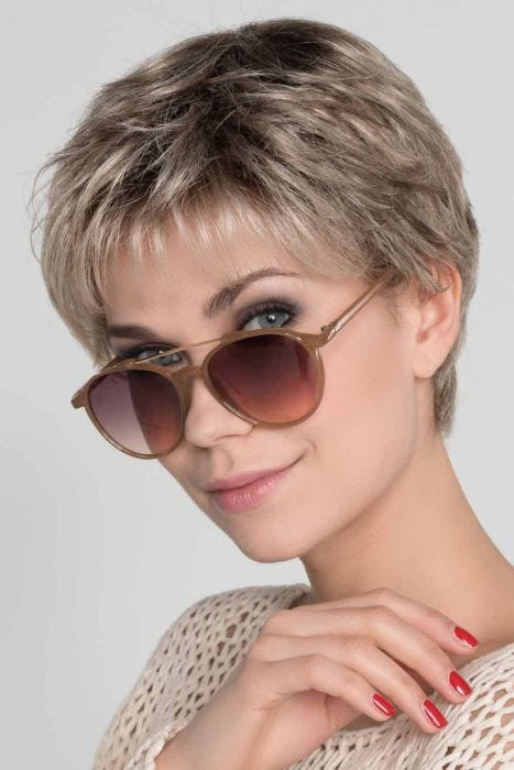 Woman in a cropped classic ash blonde pixie wig with fringe bangs