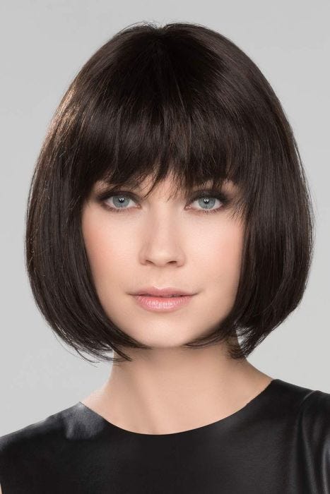 Woman in a chin length dark brown bob wig with choppy bangs