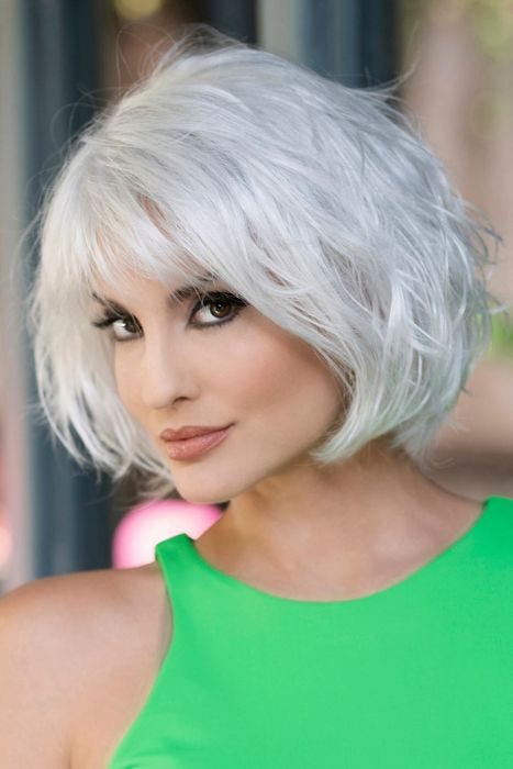 Woman in a chin length silver wavy wig with fringe bangs
