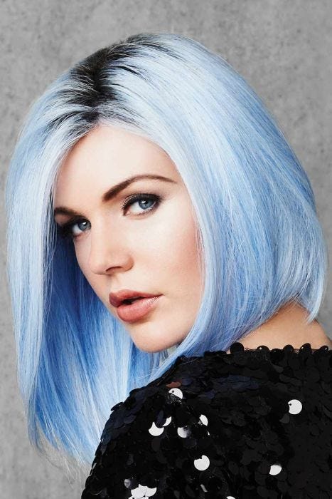 Woman in a past the shoulders pastel blue angled bob wig with dark roots