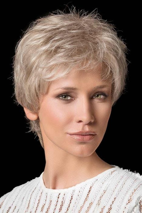 Woman in a tousled light blonde short pixie wig with fringe bangs
