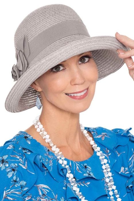 Woman in brimmed dressy grey summer hat with detailed side flower and bow