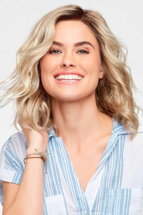 Woman in a petite shoulder length light blonde curly lace front wig