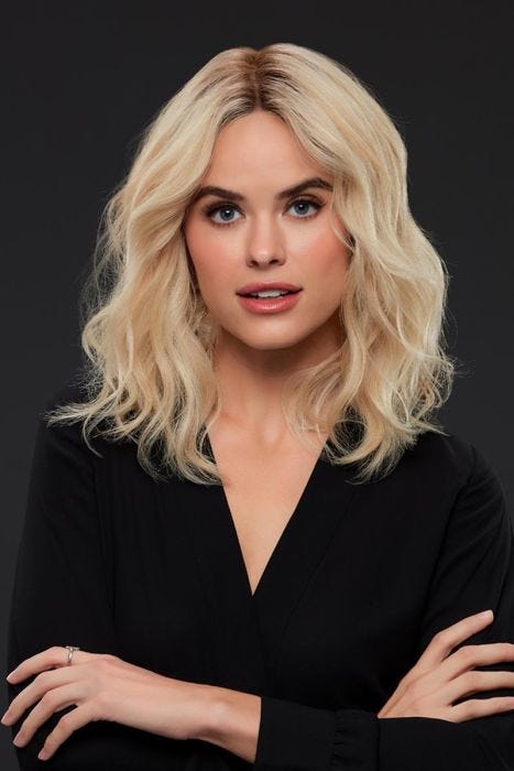 Woman in a shoulder length golden blonde curly remy human hair wig with dark roots