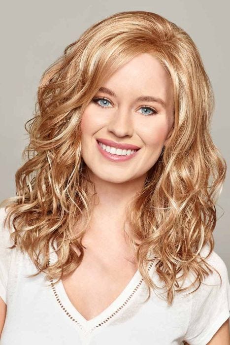 Woman in a past the shoulders curly light auburn lace front wig