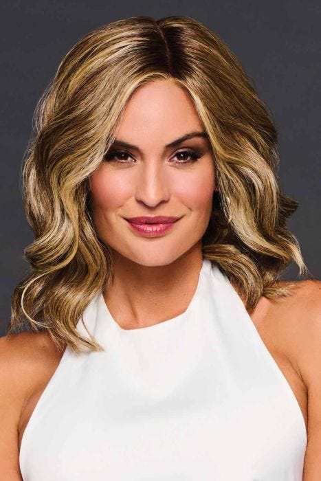 Woman in a shoulder length warm light brown wavy lace front wig