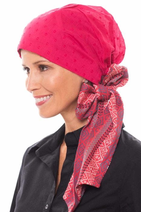 Woman in pink head covering with long printed bow