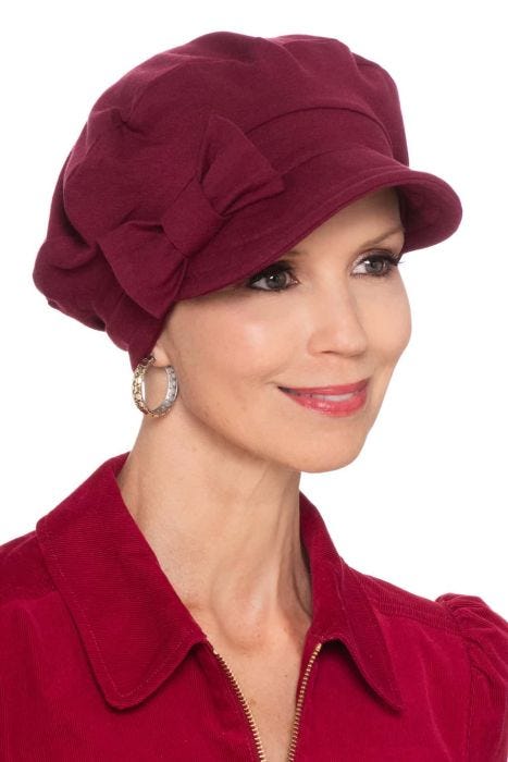 Woman in soft grey heather newsboy cap with detachable bow on the side for women with cancer