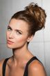 Woman with a dark ash blonde hair-wrapped scrunchie attached to her ponytail for a messy bob look