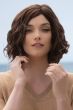 Woman in a shoulder length medium auburn curly lace front wig