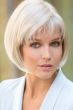 Woman in a chin length platinum blonde blunt bob wig with choppy textured bangs