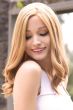 Woman in an extra long curly warm blonde lace front wig