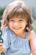 Little girl in a shoulder length light brown curly children's lace front wig
