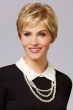 Woman in a close cropped classic pixie wig in light reddish blonde with short textured bangs