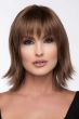 Woman in a shoulder length light brown wig with long feathered layers and fringe bangs