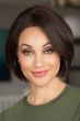 Woman in a chin length medium blonde curled-under straight bob wig