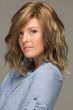 Woman in a shoulder length platinum blonde lace front wig with beach waves and dark roots