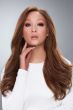 Woman in an extra long medium auburn human hair wig