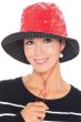 Woman in red rain hat with black and white polka dot lining