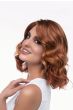 Woman in a shoulder length medium auburn curly lace front wig