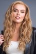 Woman in an extra long warm blonde curly lace front wig