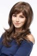 Woman in an extra long light brown wavy layered wig with side bangs