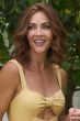 Woman in a past the shoulders medium auburn human hair wig with long layers