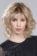 Woman in a shoulder length curly blonde wig with fringe bangs