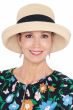 Woman in light straw summer brimmed resort hat with upturned kettle brim and black band