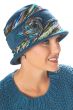 Woman in blue tweed winter hat with side flower, brim and colorful fabric inserts
