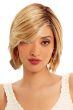 Woman in a chin length warm blonde wig with choppy layers and side bangs