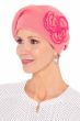 Woman in pink knitted cotton beret with side flowers for chemo patients