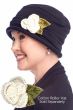 Woman in a navy Cotton Roller Hat with a crocheted cream carnation flower pin attached