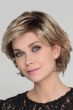 Woman in a chin length layered light blonde bob wig with side bangs
