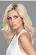 Woman in an extra long wavy platinum blonde lace front wig with dark roots