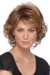Woman in a short light auburn curly wig with side bangs