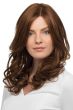 Woman in a past the shoulders curly medium auburn human hair wig