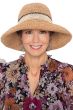 Woman in hand crocheted summer straw sun or beach hat with wire brim and two toned band for cancer patients