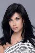 Woman in a past the shoulders black wig with long layers and side bangs