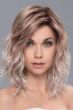 Woman in a shoulder length curly platinum and reddish blonde lace front wig