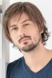 Man in a medium brown layered shag wig