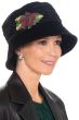 Woman in dressy black velvet winter bucket or cloche hat with detailed burgundy flowers on the side for cancer patients