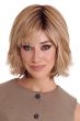 Woman in a past the chin medium auburn layered curly wig with fringe bangs