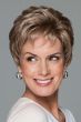 Woman in a petite curly light brown pixie wig with longer layers on the top and back
