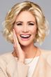 Woman in a large chin length light blonde curly lace front wig
