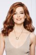 Woman in a large past the shoulders medium auburn wavy wig