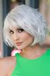 Woman in a chin length silver wavy wig with fringe bangs